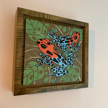 Load image into Gallery viewer, Dart frog woodcut framed in olive green solid tiger maple wood
