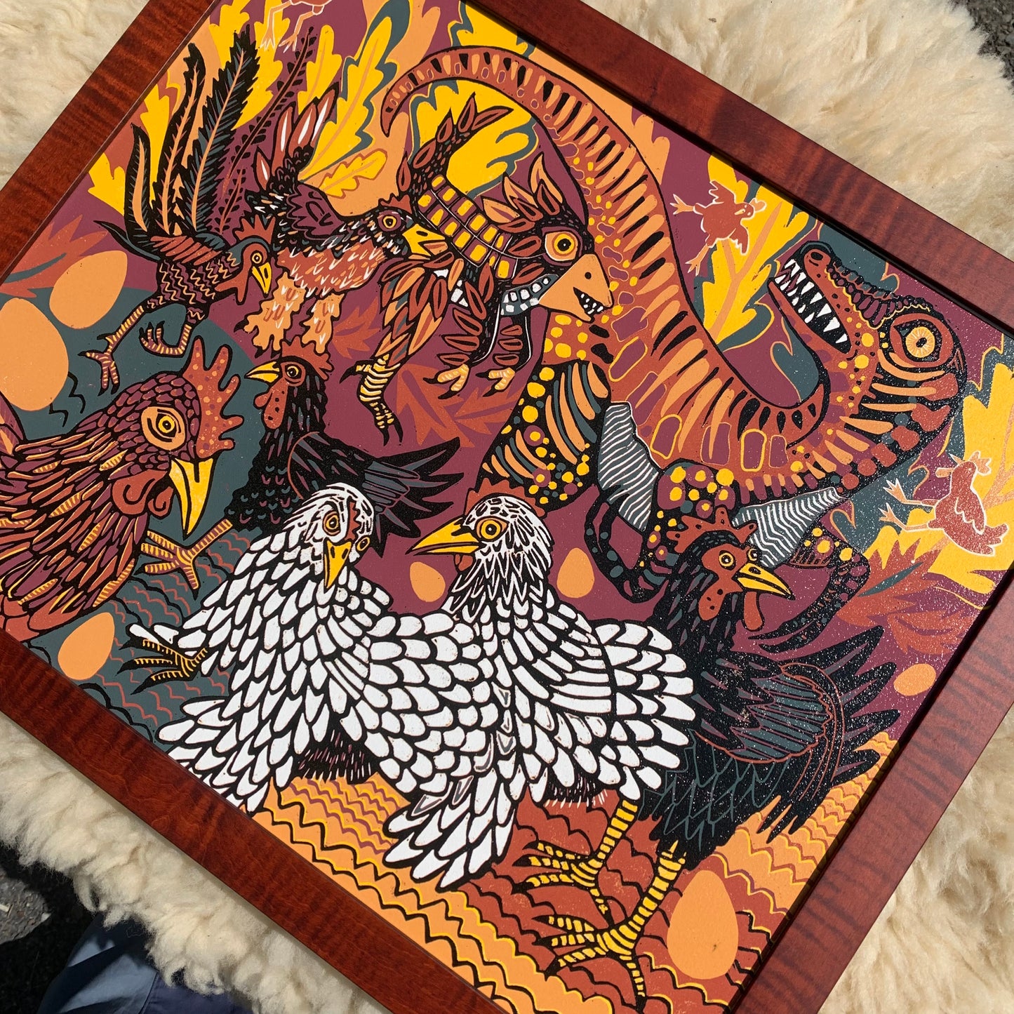 Evolution of chickens woodcut framed in curly maple