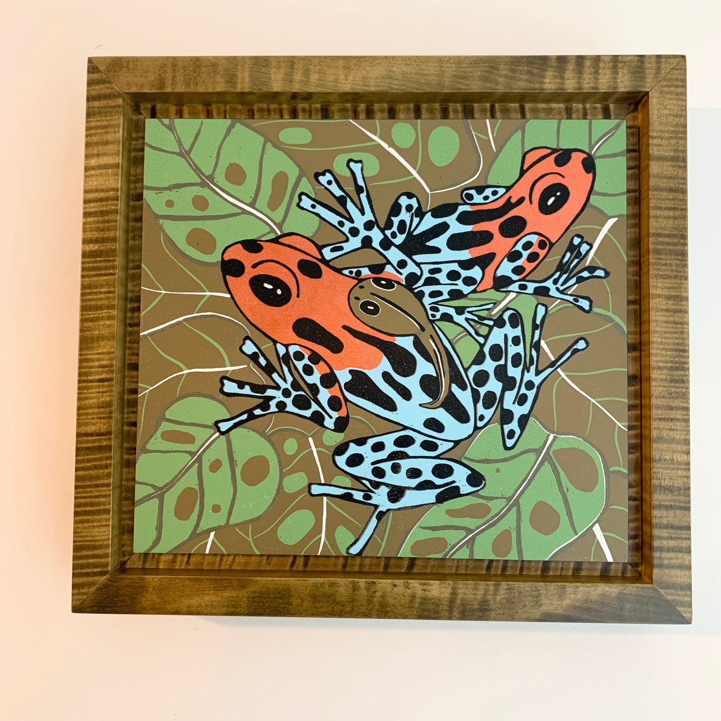 Dart frog woodcut framed in olive green solid tiger maple wood