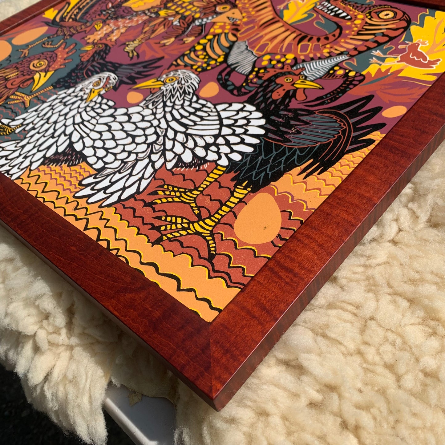 Evolution of chickens woodcut framed in curly maple
