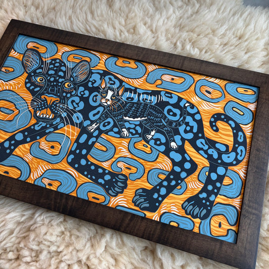 Decorative mat with a panther design on an orange and blue pattern, placed on a white surface.